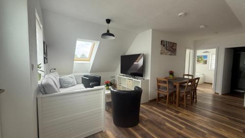 a living room with a television and a table with chairs at Ubytování U Kocábů in Drnholec