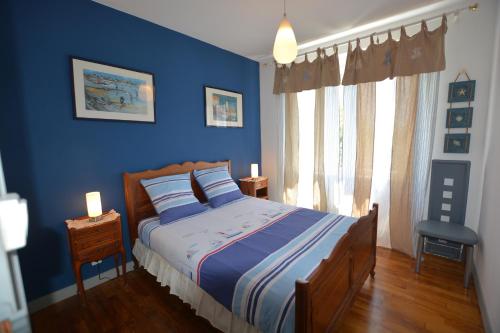 une chambre bleue avec un lit et une fenêtre dans l'établissement IROISE GRANDE MAISON en Baie d'Audierne Finistère 5 chambres, à Plozévet