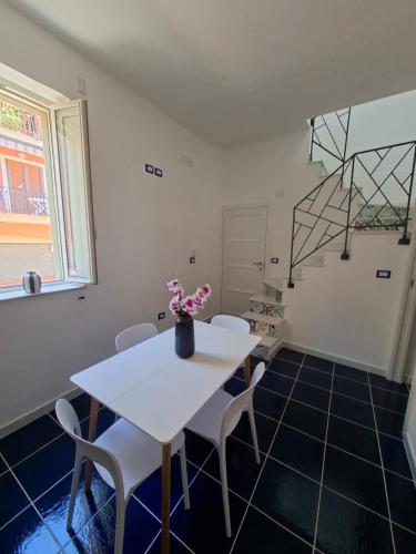 a white table and chairs in a room with a staircase at Bella Blu in Gaeta