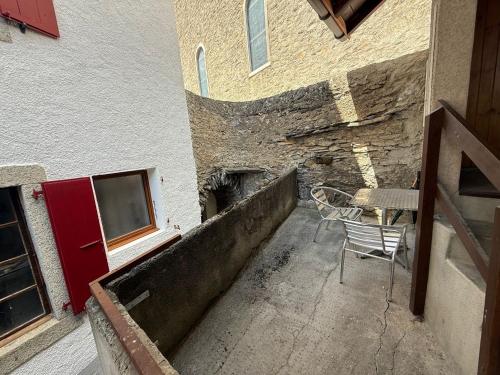 a patio with a table and a chair in front of a building at Charmant appartement Lens - Crans-Montana in Lens