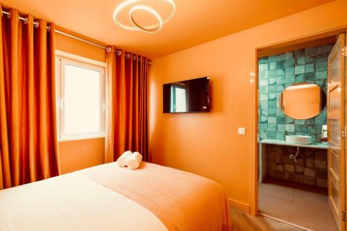 a bedroom with orange walls and a bed and a bathroom at Cascais Cosy Home - Rooms with Private Bathroom in Cascais