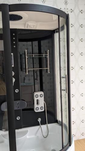 a bathroom with a shower with a mirror at Kigali White home in Kigali