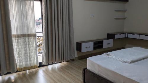 a bedroom with a bed and a large window at Kigali White home in Kigali
