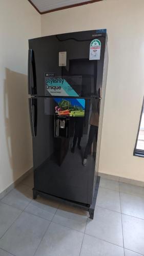 a black refrigerator with a sign on it at Kigali White home in Kigali