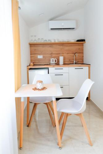 a kitchen with a white table and a white chair at Guesthouse Papac in Stolac