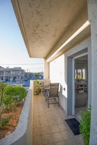 a balcony with chairs and tables on a building at casa NEFELI in Karteros