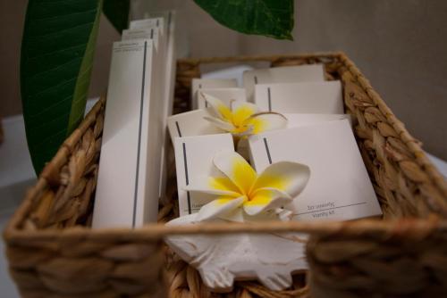 a basket with white and yellow flowers and books at casa NEFELI in Karteros