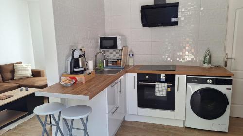 a kitchen with a sink and a washing machine at Le Cosy Place in Survilliers