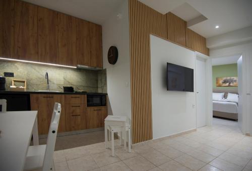 a kitchen with a table and a tv on the wall at casa NEFELI in Karteros