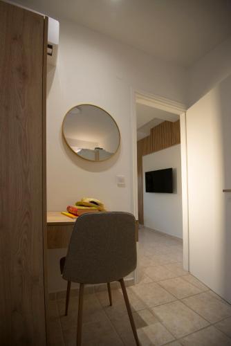 a room with a table with a chair and a mirror at casa NEFELI in Karteros