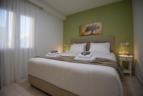 a bedroom with a large bed with towels on it at casa NEFELI in Karteros