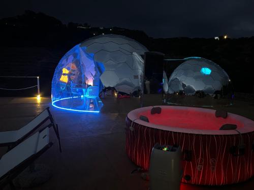 two domes with a hot tub and a fire pit at night at Palmaria Sky Bubbles Room in Ponza