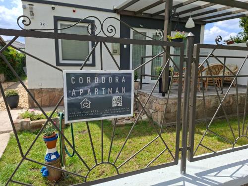 a sign on a gate in front of a house at Corddora Apartman in Mezőkövesd