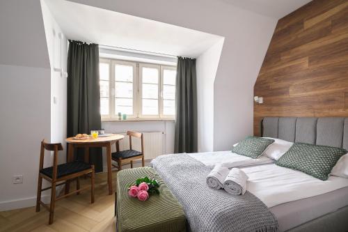 a bedroom with a bed and a small table with a table at Solny Square Aparthotel in Wrocław