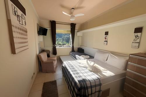 a small room with a bed and a chair at FLAT-Cavalinho Branco-Águas de Lindoia in Águas de Lindóia
