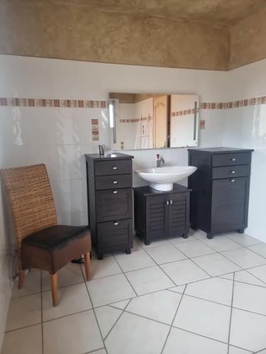 La salle de bains est pourvue d'un lavabo et d'une chaise. dans l'établissement Villa au pied d'une colline, à La Farlède