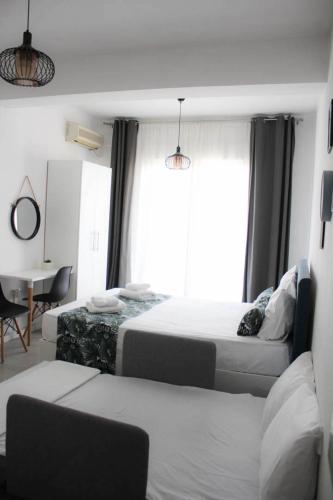 ein Hotelzimmer mit zwei Betten und einem Schreibtisch in der Unterkunft StuDio 57 (5) in Alexandroupoli