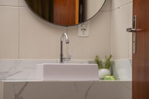 un bagno con lavandino e specchio di Pousada Villa D'Ouro a Penha