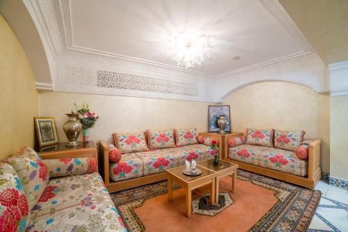 a living room with couches and a table at Hotel Palais Al Bahja in Marrakech