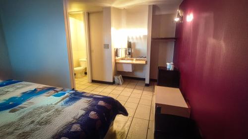 a bedroom with a bed and a bathroom with a sink at Travel Inn in Sunnyside