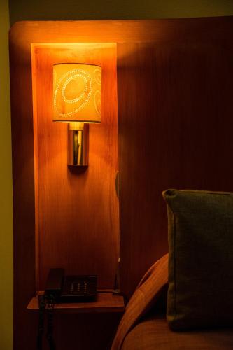 a lamp on a wall next to a bed at Hotel Palais Al Bahja in Marrakech