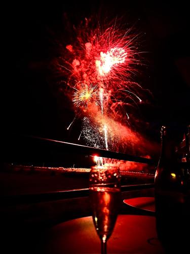 un feu d'artifice explosant dans le ciel nocturne au-dessus d'une plage dans l'établissement Les cygnes de Criel-sur-Mer, à Criel-sur-Mer