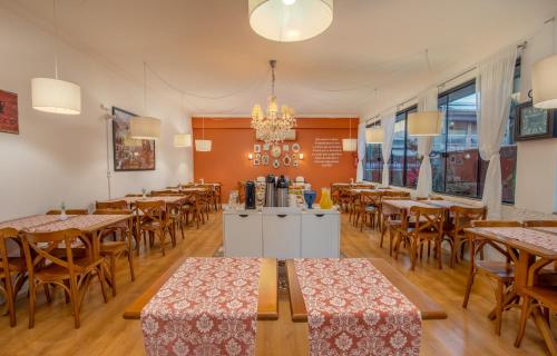 een eetkamer met tafels en stoelen en een kroonluchter bij Pousada Villa D'Ouro in Penha