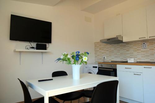 a kitchen with a white table with a vase of flowers on it at GIANGY HOME in Casteldaccia