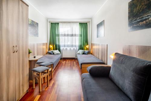 a living room with a row of couches and a table at 4 Pory Roku - Węgierska Górka in Węgierska Górka