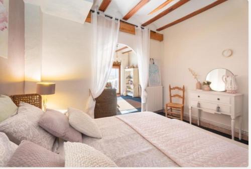 una camera da letto con un grande letto bianco e una scrivania di La Posada Rural el Ensueño a Alcublas