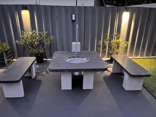 a picnic table with two benches in a backyard at Annabella Vendégház in Hajdúszoboszló