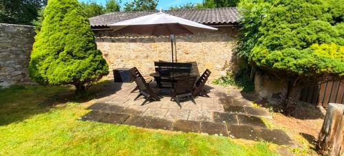 a table and chairs with an umbrella on a patio at U Boží hory. in Žulová