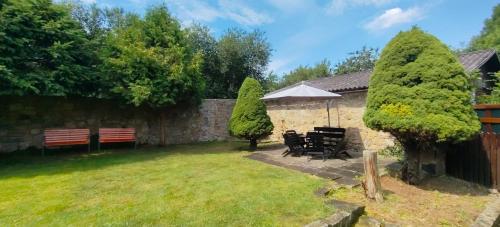a garden with a table and chairs and an umbrella at U Boží hory. in Žulová
