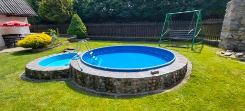 a swimming pool in a yard with a rock around it at U Boží hory. in Žulová