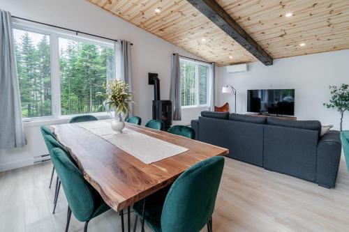 een eetkamer met een houten tafel en groene stoelen bij Villa Le Frigg spa swimming pool in Valcartier Station