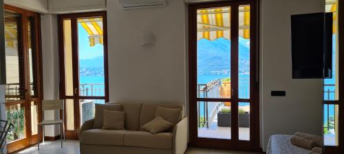 a living room with a couch and sliding glass doors at Villa gli Ulivi Chalten Apartment in Perledo