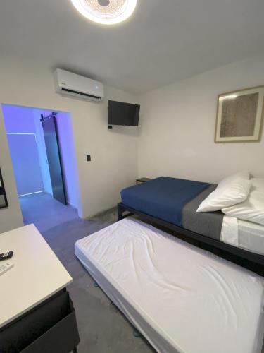 a room with two beds and a blue door at DGM Lofts GPE 6 cerca Estadio Rayados in Monterrey