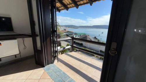 a door to a balcony with a view of the ocean at Pousada Caminho do Mar in Bombinhas