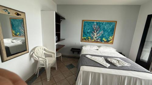 a hotel room with a bed and a mirror at Pousada Caminho do Mar in Bombinhas