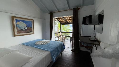 a bedroom with a bed and a door to a patio at Pousada Caminho do Mar in Bombinhas