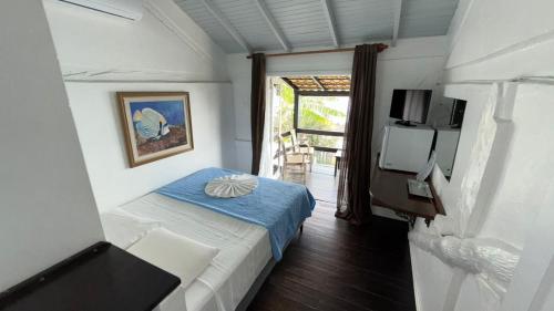 a small room with a bed and a tv at Pousada Caminho do Mar in Bombinhas