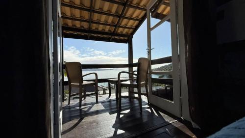 a balcony with chairs and a view of the ocean at Pousada Caminho do Mar in Bombinhas