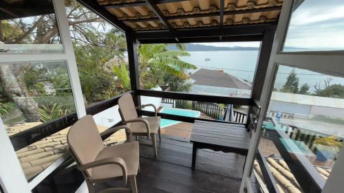 a house with a balcony with a table and chairs at Pousada Caminho do Mar in Bombinhas