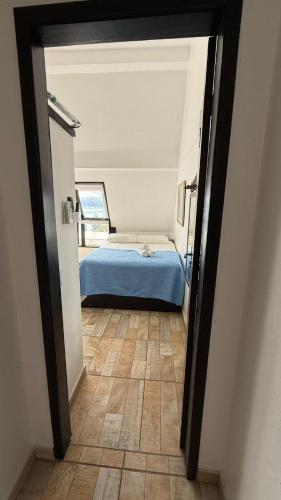 a bedroom with a blue bed and a tile floor at Pousada Caminho do Mar in Bombinhas