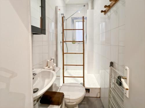 une salle de bain blanche avec des toilettes et un lavabo dans l'établissement Functional apartment, Belleville, Paris 11, à Paris