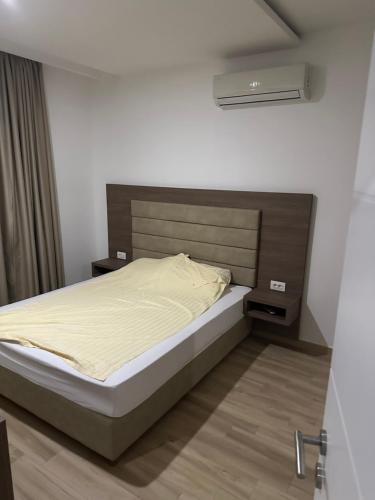 a bedroom with a bed with a brown headboard at AB LUX Apartmani 406 in Kravlja