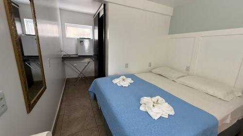 a bedroom with a bed with two flowers on it at Pousada Caminho do Mar in Bombinhas