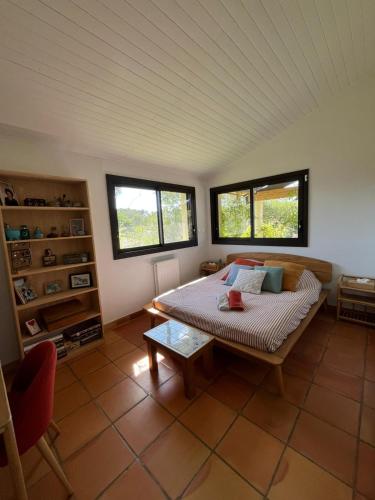 une chambre avec un lit dans une pièce avec des fenêtres dans l'établissement Jolie Villa spacieuse, à Saint-Clément-de-Rivière