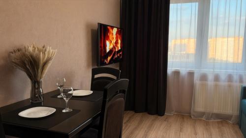 a dining room with a table with a fireplace in front of a window at New Business-Class Apartment 1 хв від метро in Kyiv