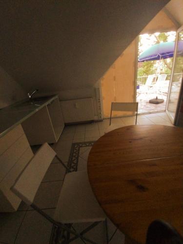 a kitchen with a wooden table and white chairs at Massage studio-spa in Ginsheim-Gustavsburg